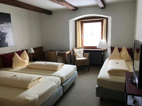 a hotel room with two beds and a window at Hôtel Bodenhaus in Splügen