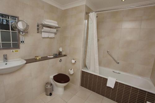y baño con bañera, aseo y lavamanos. en Farington Lodge Hotel, en Preston