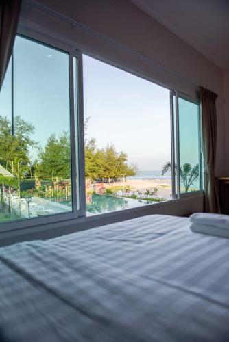 a bedroom with a bed and a view of the beach at Seaman Resort in Haad Chao Samran