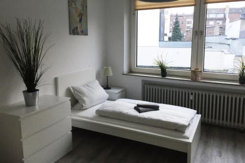 a white room with a bed and a window at Nice and cozy apartment with Wifi and balcony in Neuss