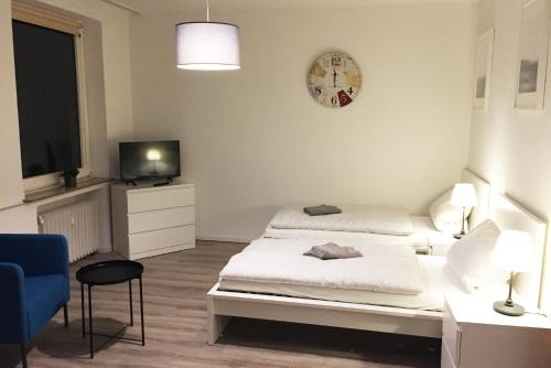 sypialnia z łóżkiem, telewizorem i krzesłem w obiekcie Nice and cozy apartment with Wifi and balcony w mieście Neuss