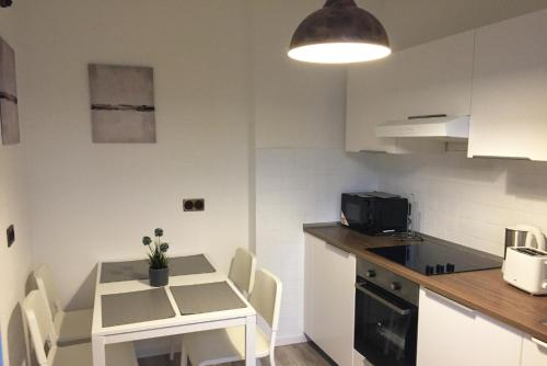 a kitchen with a small white table and chairs in a room at Nice and cozy apartment with Wifi and balcony in Neuss