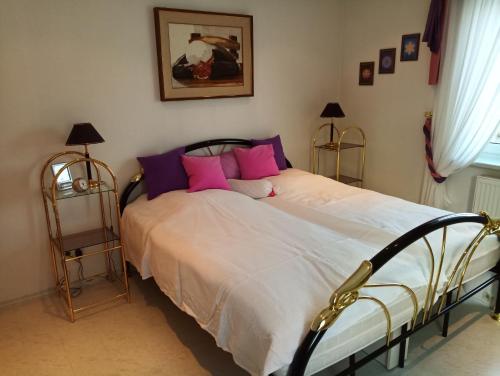 a bedroom with a bed with pink and purple pillows at Ferienwohnung Waldblick im Haus Ludwig in Masserberg