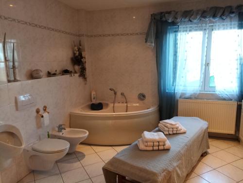 een badkamer met een bad, een toilet en een wastafel bij Ferienwohnung Waldblick im Haus Ludwig in Masserberg
