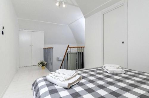 een witte kamer met een zwart-wit geruit bed bij San Lorenzo House in Napels