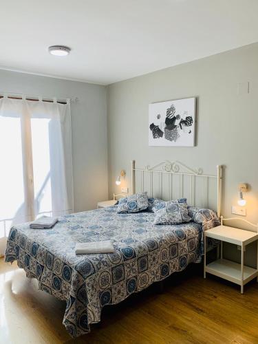 a bedroom with a bed with a blue comforter at Apartamentos Maladeta in Benasque