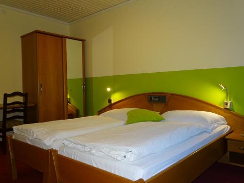 a bedroom with a large bed with a green wall at Gasthof Torwirt in Lavamünd