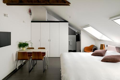 Un dormitorio con dos camas y una mesa y sillas. en B&B Bed and Beyond, en Opglabbeek