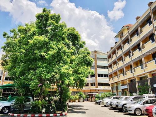 a tree in a parking lot next to a building at Paholyothin Park Place in Bangkok