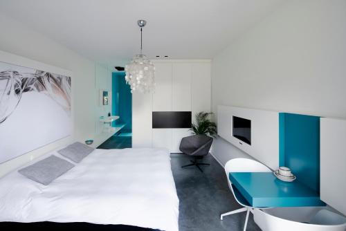 - une chambre avec un lit blanc et un bureau bleu dans l'établissement B&B Bed and Beyond, à Opglabbeek