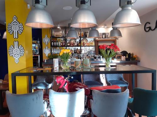 a bar with chairs and a table with flowers at Gucio - pokoje z restauracją Szczyrk in Szczyrk