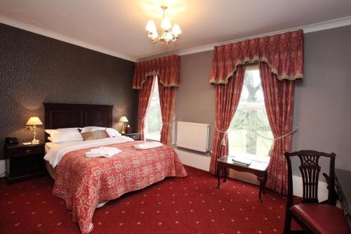 a hotel room with a bed and a dresser at Farington Lodge Hotel in Preston