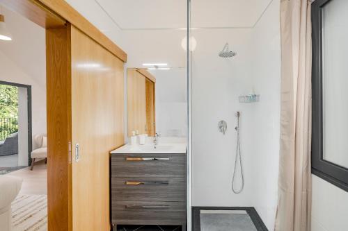 uma casa de banho com um lavatório e um chuveiro em Oscar's House by An Island Apart em Ponta do Sol