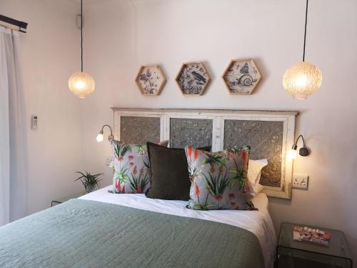 a bedroom with a bed with four clocks on the wall at INBLOEM in Bloemfontein