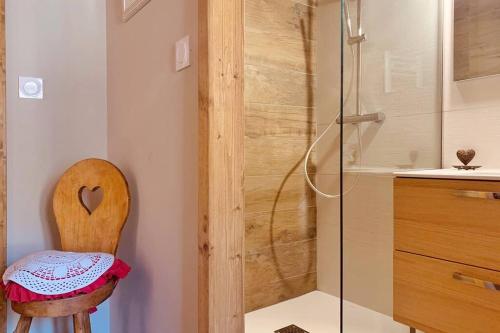 uma casa de banho com um chuveiro e uma cadeira de madeira em Charmante Maison de village: Prestation de Qualité, Tout confort, Terrasse em Targassonne