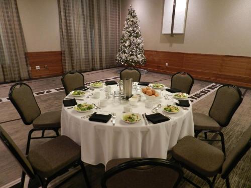 a table with food and a christmas tree in a room at Radisson Hotel & Conference Centre Calgary Airport in Calgary