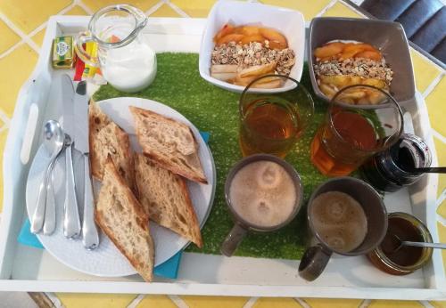 a tray of food with toast and drinks on a table at La Sornière in Talmont
