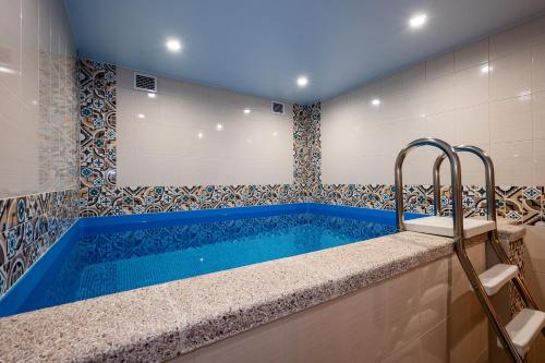 een badkamer met een blauw bad in een kamer bij Лесная Сказка in Goryachiy Klyuch