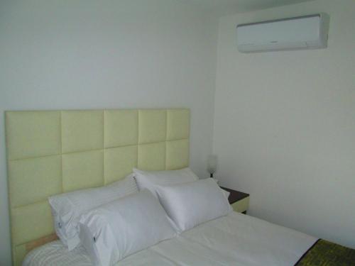 a bedroom with a white bed with white sheets and pillows at Hotel Ipanema Meridian in Neiva