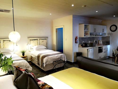 a hotel room with two beds and a couch at INBLOEM in Bloemfontein
