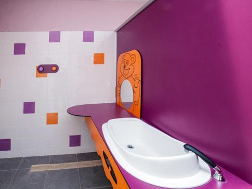 a purple bathroom with a sink and a bath tub at Oh! Campings - Le Clos du Rhône in Saintes-Maries-de-la-Mer