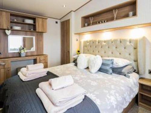 a bedroom with a large bed with towels on it at Cairn View Chalet in Aviemore