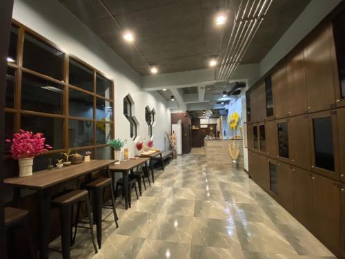 Un restaurante con mesas y sillas en un pasillo. en Ray Hostel, en Chiang Mai