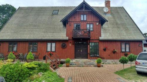 a large red house with a black door at Dom Gościnny Matysowka in Jarosławiec