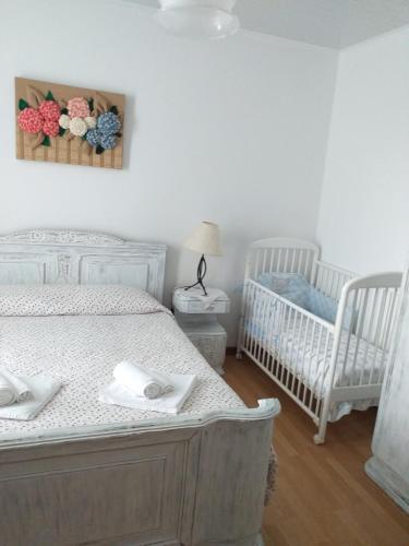 - une chambre avec 2 lits jumeaux et 2 lits bébé dans l'établissement Casa da Rosarinha, à Água de Alto