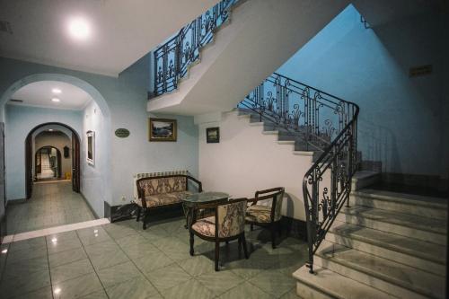 a staircase in a house with a couch and a table at Giuseppe Hotel in Kazan