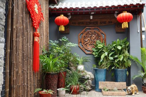 un groupe de plantes en pot sur le côté d'un bâtiment dans l'établissement Beijing Yue Bin Ge Courtyard Hotel, à Pékin