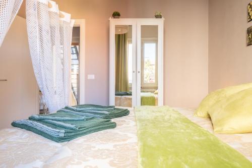 1 dormitorio con 1 cama con toallas verdes en CASA PETRONIO APARTMENTS BOLOGNA CENTER, en Bolonia