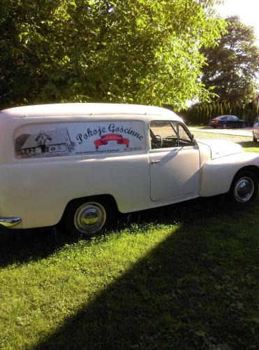 an old white car parked in the grass at Dom Gościnny Matysowka in Jarosławiec