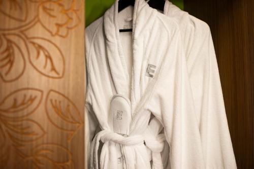 a white robe is hanging in a closet at Elite Hotel Esplanade in Malmö