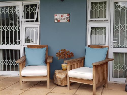 two chairs sitting on the front porch of a house at B&B on Buckingham Guest House in Johannesburg