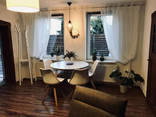 a dining room with a table and chairs and windows at Ferienwohnung Willi I in Spremberg