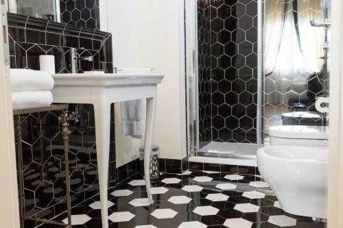 - une salle de bains en noir et blanc avec lavabo et toilettes dans l'établissement Flor in Florence, à Florence