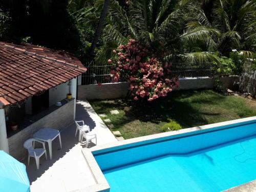 a house with a swimming pool and a palm tree at Hostel Meu Sossego Vilas in Lauro de Freitas
