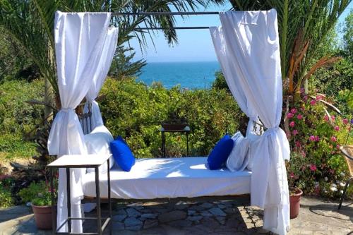 a bed with blue pillows sitting under a canopy at A Hotel Boutique Pelluhue in Pelluhue