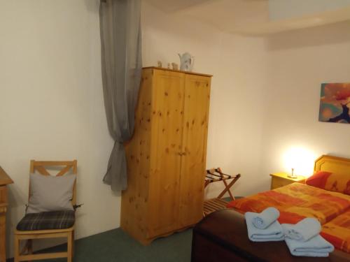 um quarto com uma cama e um armário de madeira em Ferienwohnung Windecker Ländchen em Windeck