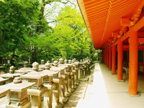 a row of tables in a garden with orange beams at Guesthouse Nara Komachi in Nara