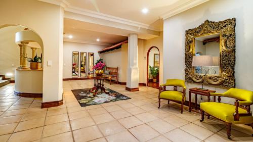 a lobby with yellow chairs and a mirror at Christies at 32 on Russell in Nelspruit