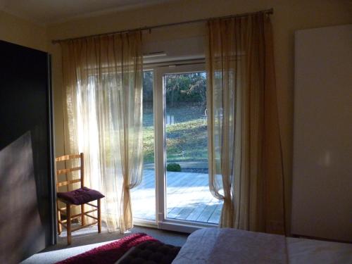 a bedroom with a bed and a sliding glass door at Gîte d'Maïsala Les Mésanges in Heidwiller