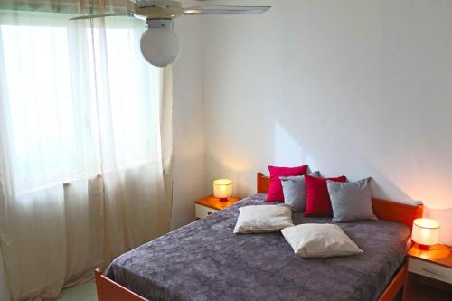 a bedroom with a bed with red and white pillows at Holiday Apartment Karm Otranto 6 places in Otranto