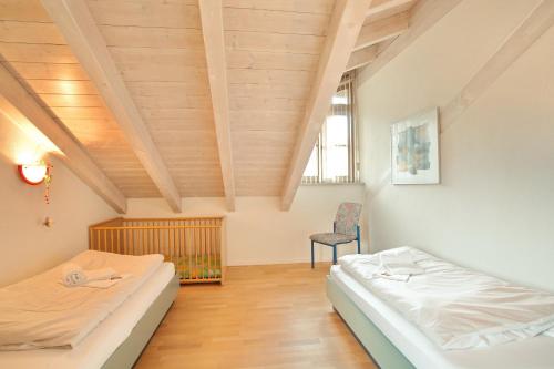 1 dormitorio con 2 camas y 1 silla en Sippel, en Sonthofen
