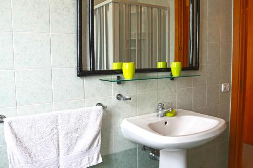 a bathroom with a sink and a mirror and towels at Holiday Apartment Karm Otranto 6 places in Otranto