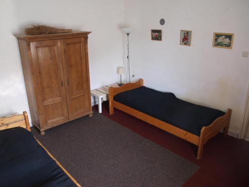 a bedroom with two beds and a wooden cabinet at Hibiszkusz Haz in Bekölce