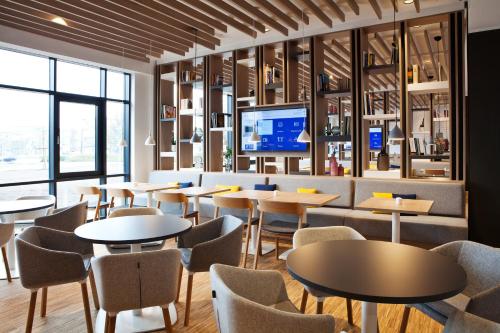 um restaurante com mesas e cadeiras e uma televisão em Holiday Inn Express - Darmstadt, an IHG Hotel em Darmstadt