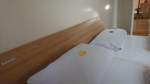 a white bed with a wooden headboard in a room at Architekten Villa in Theaternähe in Meiningen