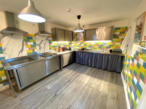 una cucina con pavimenti in legno ed elettrodomestici in acciaio inossidabile di Smart Russell Square Hostel a Londra